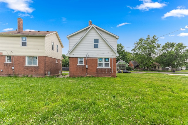 rear view of house featuring a yard