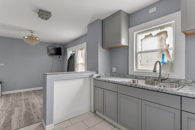 13437 E State Fair St, Detroit, MI 48205 - kitchen with a sink, light countertops, gray cabinets, baseboards, and a peninsula