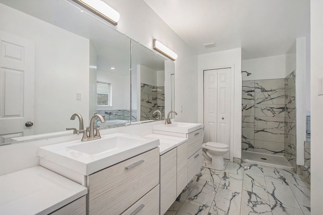 bathroom featuring vanity, toilet, and tiled shower