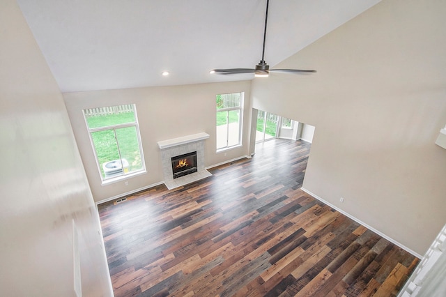 unfurnished living room featuring ceiling fan, a fireplace, high vaulted ceiling, and dark hardwood / wood-style floors