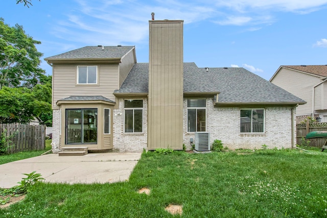 rear view of house featuring a lawn, cooling unit, and a patio area