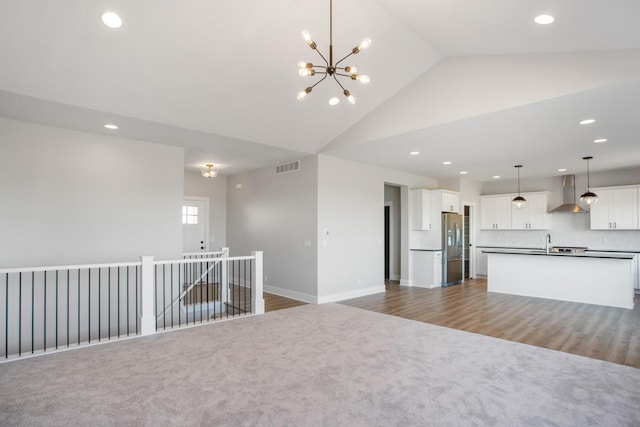 9139 Perry Ct, Zeeland, MI 49464 - kitchen with wall chimney range hood, open floor plan, a sink, recessed lighting, and stainless steel refrigerator with ice dispenser