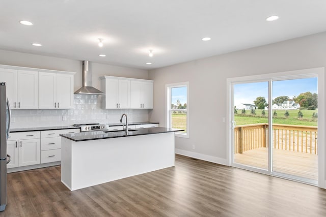9139 Perry Ct, Zeeland, MI 49464 - kitchen featuring wall chimney exhaust hood, dark countertops, stainless steel appliances, a sink, and decorative backsplash
