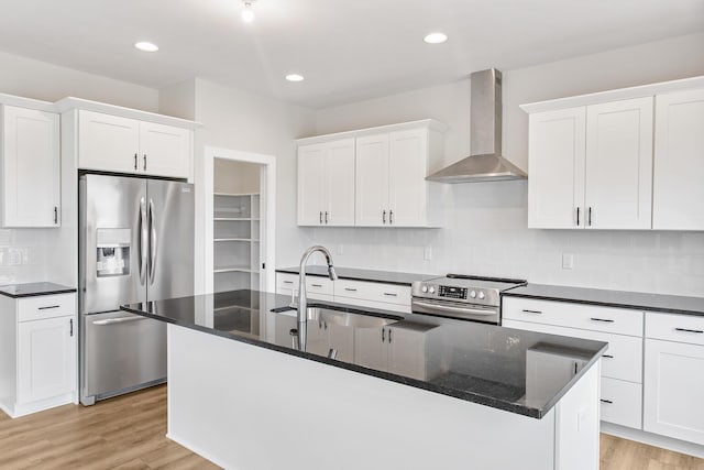 9139 Perry Ct, Zeeland, MI 49464 - kitchen featuring stainless steel appliances, wall chimney range hood, a sink, a kitchen island with sink, and white cabinetry