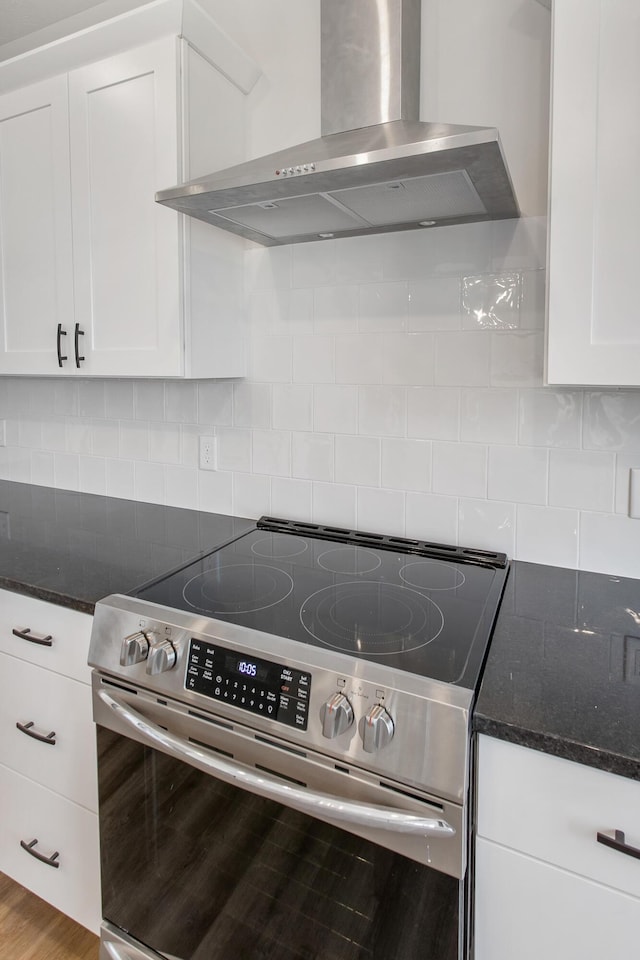 9139 Perry Ct, Zeeland, MI 49464 - kitchen featuring electric stove, wall chimney exhaust hood, white cabinets, dark stone countertops, and decorative backsplash