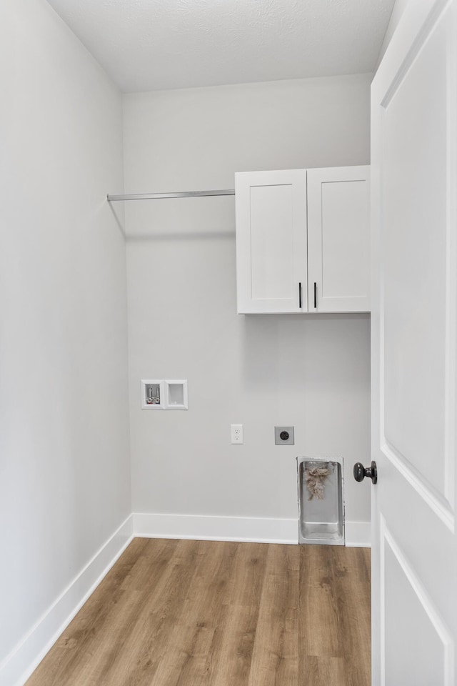9139 Perry Ct, Zeeland, MI 49464 - laundry room featuring hookup for an electric dryer, light wood-type flooring, washer hookup, cabinet space, and baseboards