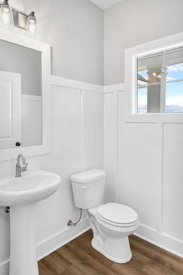 9139 Perry Ct, Zeeland, MI 49464 - bathroom featuring wood finished floors, toilet, a sink, and baseboards