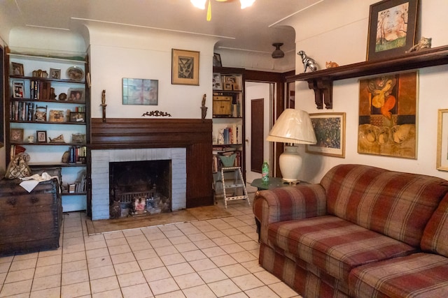 tiled living room featuring a brick fireplace