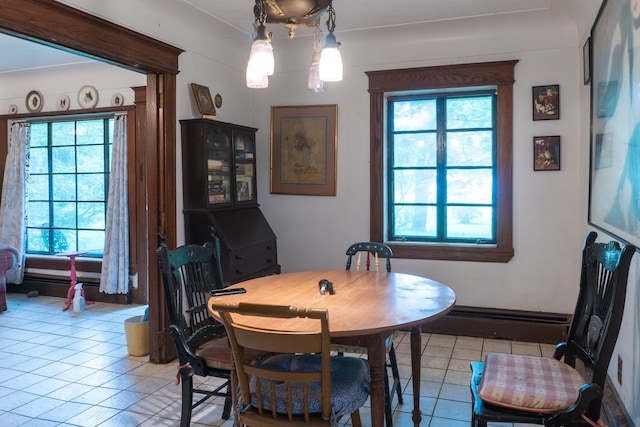 dining room featuring light tile patterned floors and a baseboard heating unit