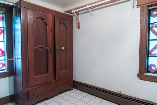 spacious closet with a baseboard radiator and light tile patterned flooring