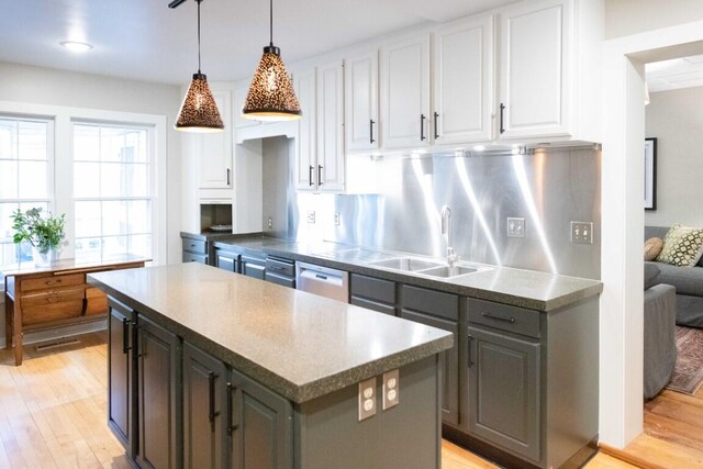 kitchen featuring a center island, sink, tasteful backsplash, light hardwood / wood-style flooring, and white cabinets