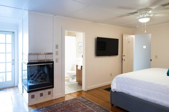 bedroom featuring ensuite bath, ceiling fan, hardwood / wood-style floors, and crown molding