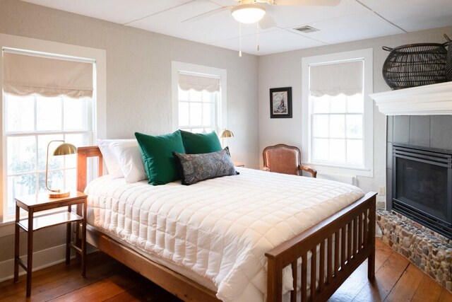 bedroom with ceiling fan, dark hardwood / wood-style flooring, and multiple windows