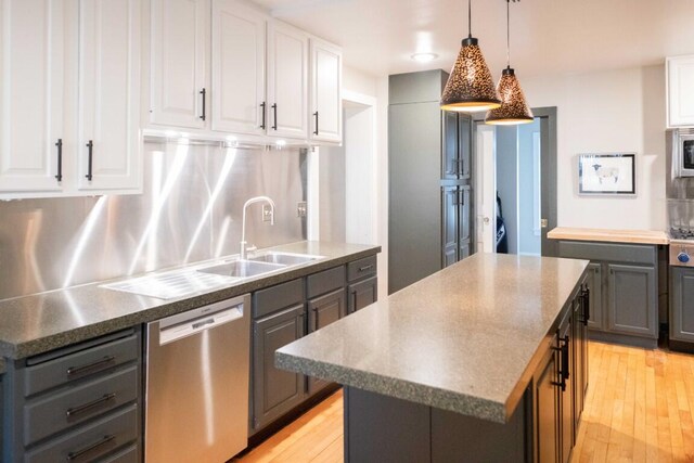 kitchen featuring light wood-type flooring, a center island, stainless steel appliances, and white cabinetry