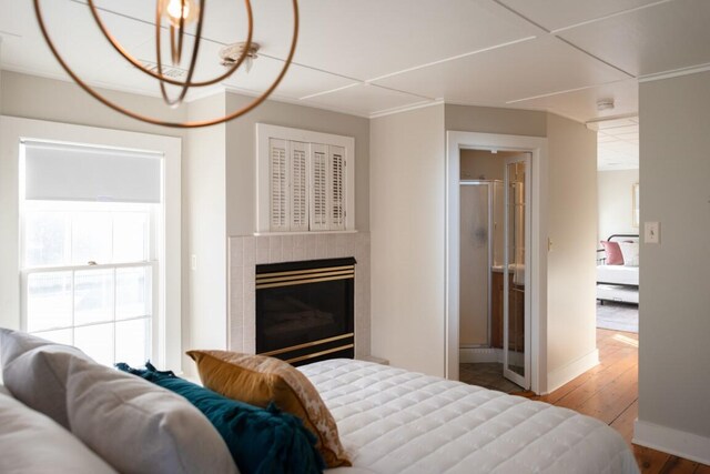 bedroom with wood-type flooring and ensuite bath