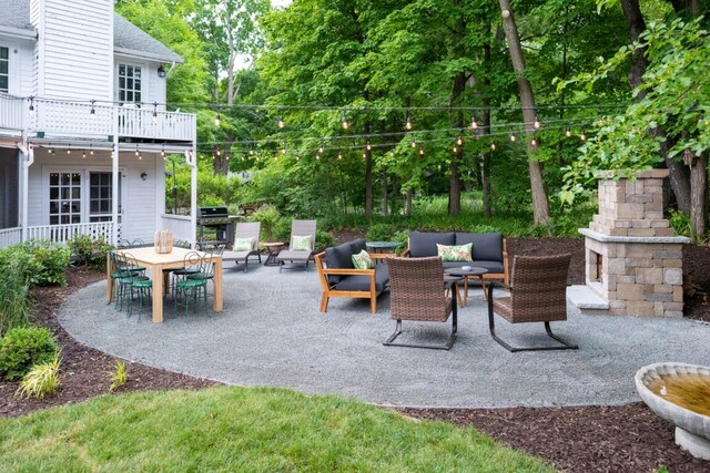 view of patio / terrace featuring an outdoor living space with a fireplace, a balcony, and grilling area