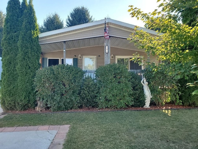 view of property exterior with a lawn and a porch