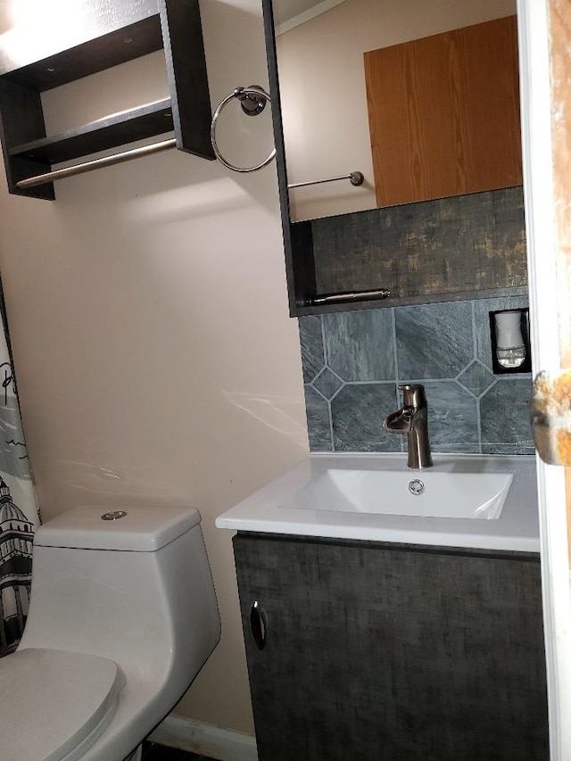 bathroom with backsplash, vanity, and toilet