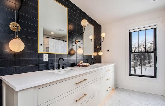 kitchen featuring white cabinetry, sink, and hanging light fixtures