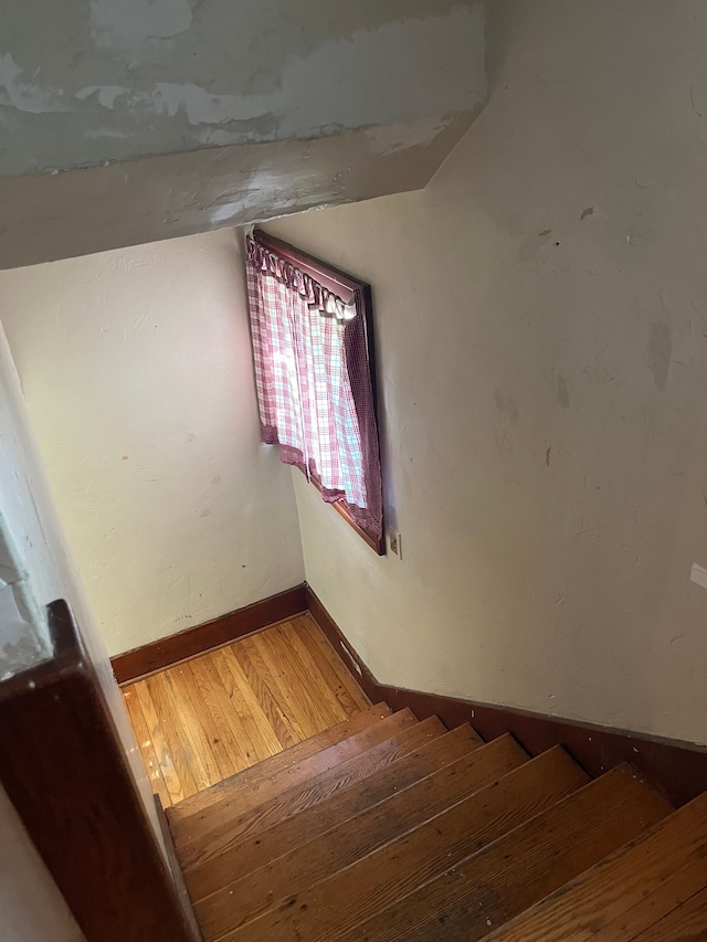 staircase featuring hardwood / wood-style flooring and vaulted ceiling