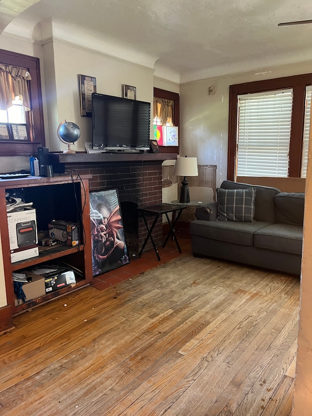 living room featuring a brick fireplace and hardwood / wood-style flooring