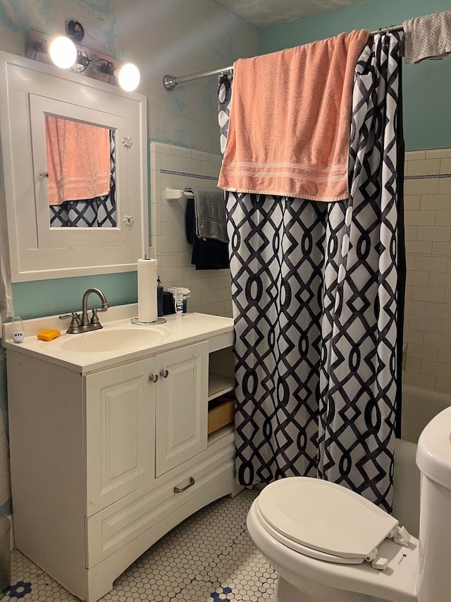 full bathroom with tile patterned floors, shower / bath combination with curtain, toilet, vanity, and tile walls