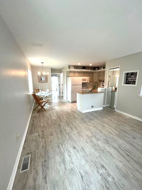 unfurnished living room featuring hardwood / wood-style flooring and a chandelier