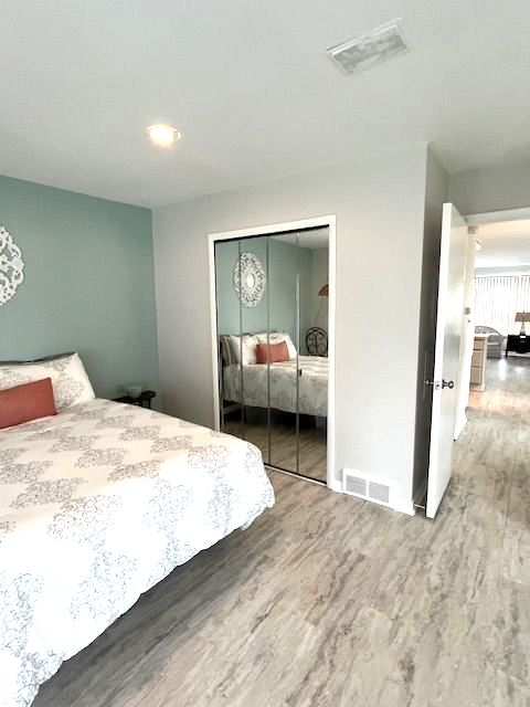 bedroom featuring wood-type flooring and a closet