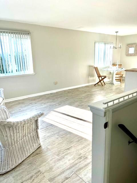 living room featuring plenty of natural light, hardwood / wood-style floors, and a notable chandelier