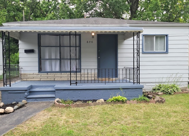 doorway to property featuring a yard and covered porch