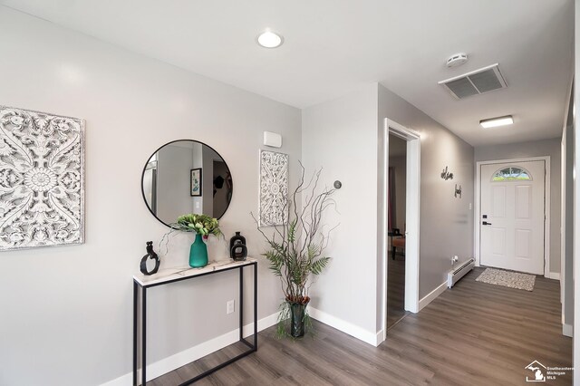 corridor featuring dark wood-type flooring and a baseboard radiator