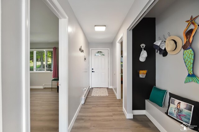 interior space featuring a baseboard heating unit and light hardwood / wood-style flooring