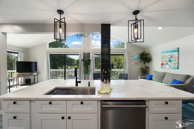 kitchen with pendant lighting, sink, light stone countertops, and white cabinets