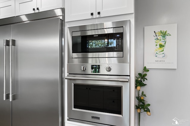 kitchen with built in appliances and white cabinetry