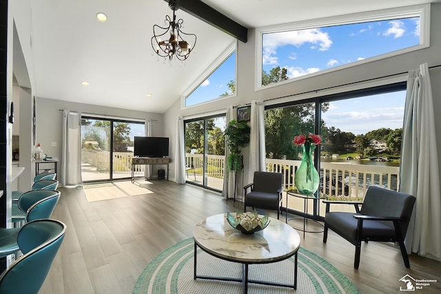 sunroom featuring a chandelier and vaulted ceiling with beams