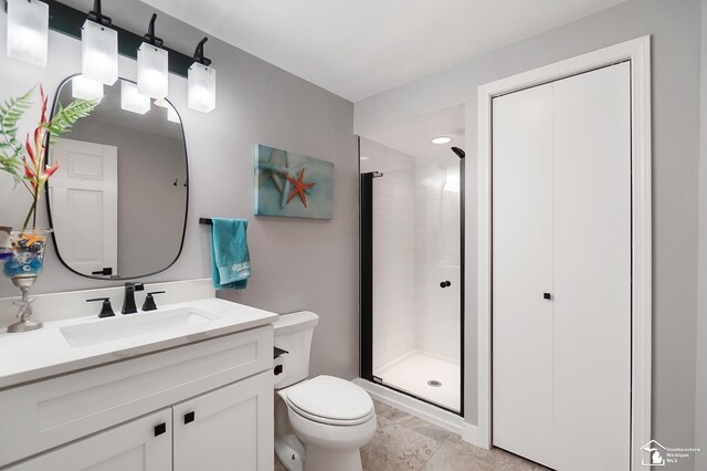 bathroom with vanity, an enclosed shower, and toilet