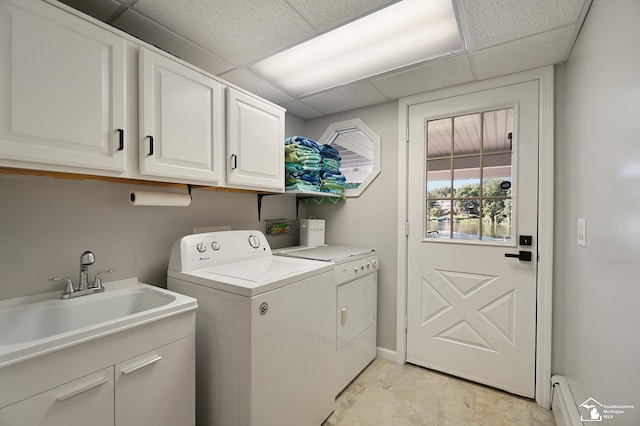 washroom with separate washer and dryer, sink, a baseboard radiator, and cabinets