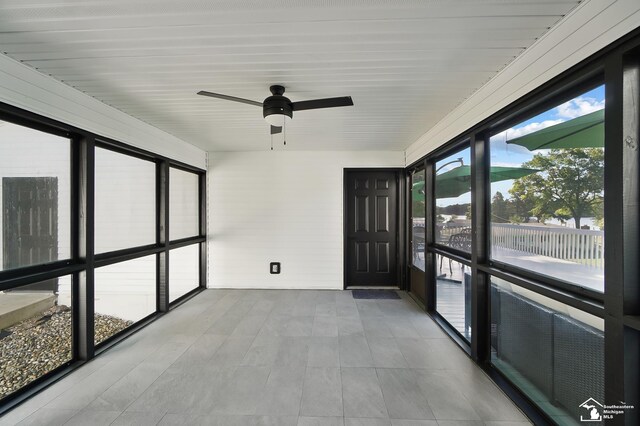 unfurnished sunroom with ceiling fan