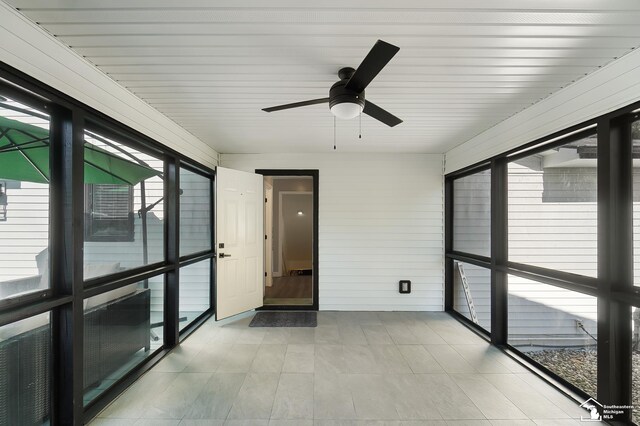 unfurnished sunroom featuring ceiling fan