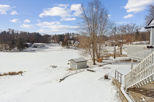 yard layered in snow with a storage unit