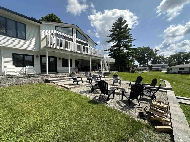 view of yard featuring a patio, a balcony, and a fire pit