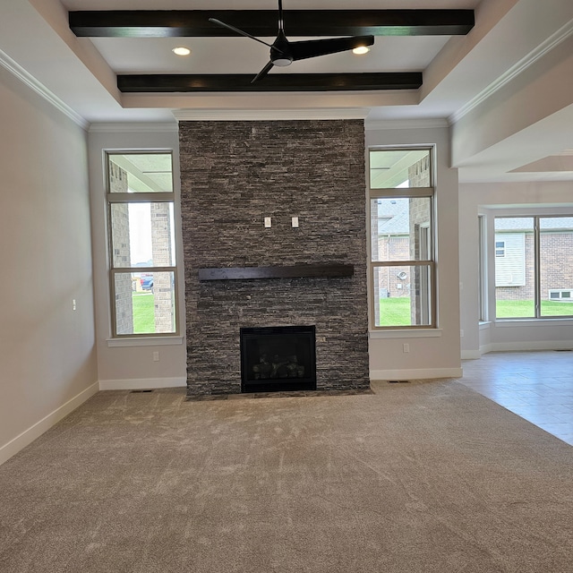 unfurnished living room featuring a stone fireplace, ceiling fan, a raised ceiling, light colored carpet, and beamed ceiling