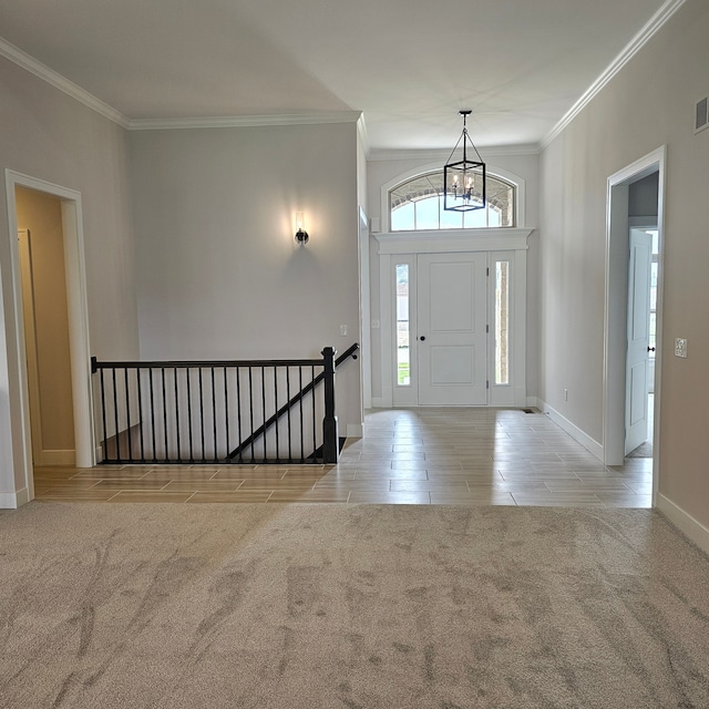 entrance foyer with light colored carpet, crown molding, and a notable chandelier