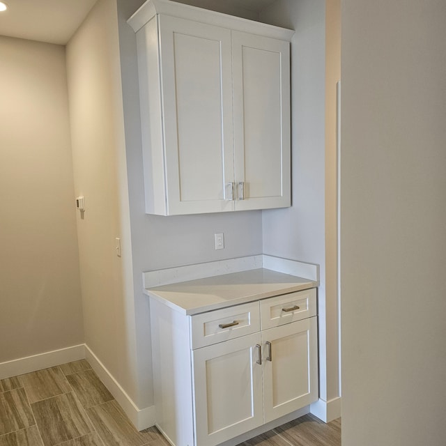 interior space with light hardwood / wood-style floors and white cabinets