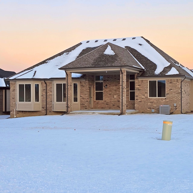 snow covered property featuring central AC unit