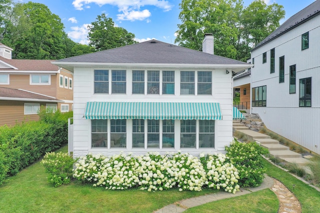 rear view of house featuring a lawn