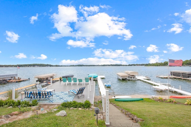 dock area with a lawn and a water view