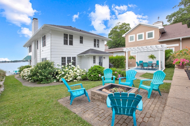 back of house with a pergola, a water view, a fire pit, a patio, and a lawn