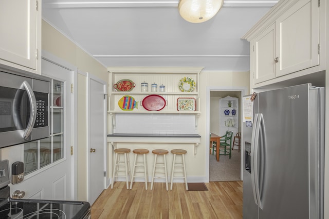 kitchen featuring white cabinetry, appliances with stainless steel finishes, and light hardwood / wood-style flooring