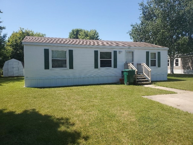 manufactured / mobile home with a storage unit and a front yard